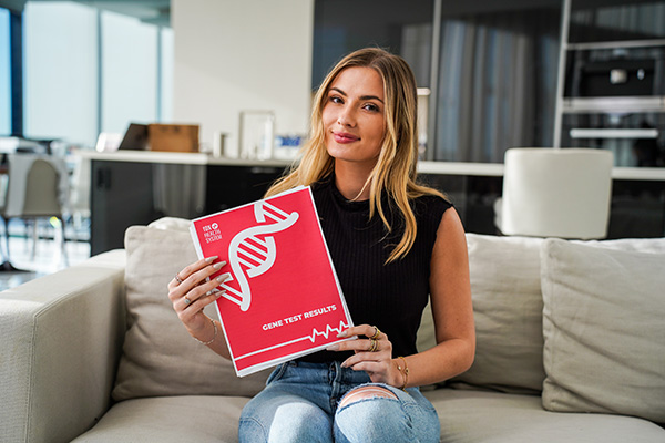 A Woman Sits with Her 10X Health System Genetic Testing Results