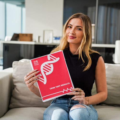 a woman holding her 10X Health System genetic test results