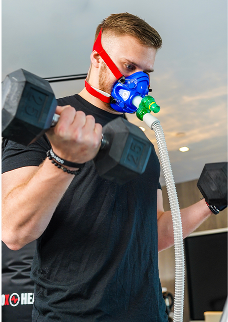 lifting dumbbells while wearing an oxygen mask