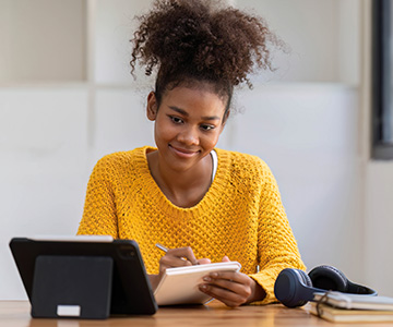 a woman taking notes while hearing a personal report on her 10X Health Blood Test