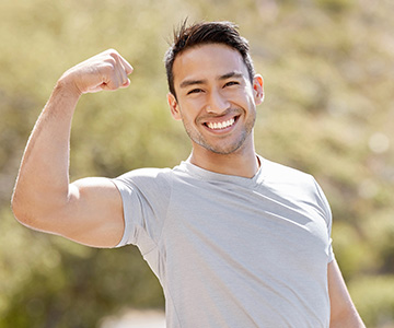 a man happily flexing his bicep after the 10X Health System helped him feel his best