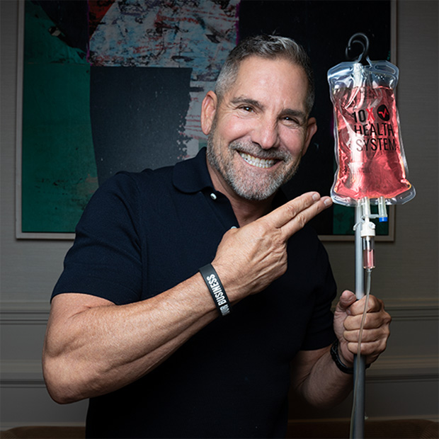 Grant Cardone smiling and pointing at a 10X Health IV therapy bag