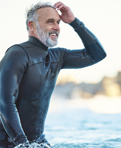 man in wetsuit standing in water