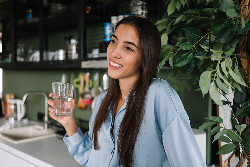 a woman drinking water while fasting before a 10X Health System blood test