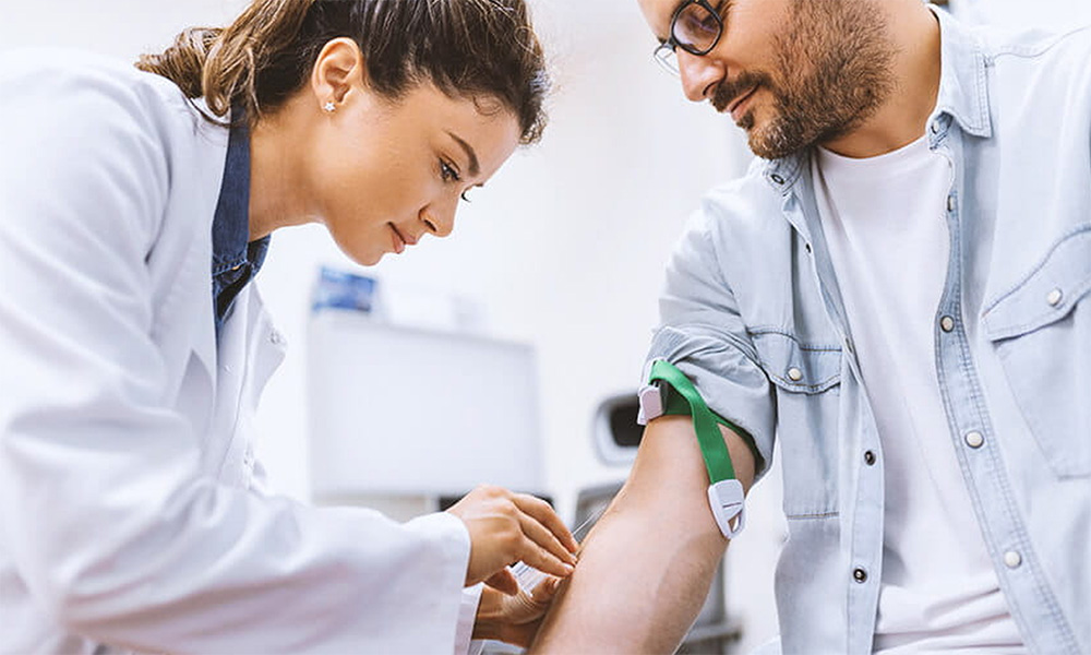 a 10X Health team member taking a visitor blood sample