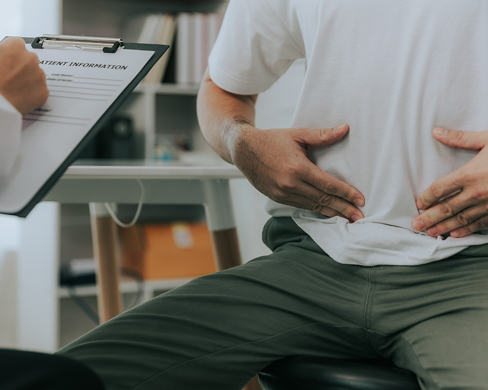 a man gesturing to his stomach during a consultation a man gesturing to his stomach during a consultation