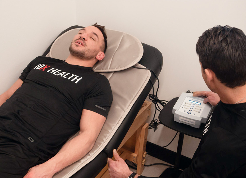 athlete laying on a PEMF mat at a 10X Health clinic