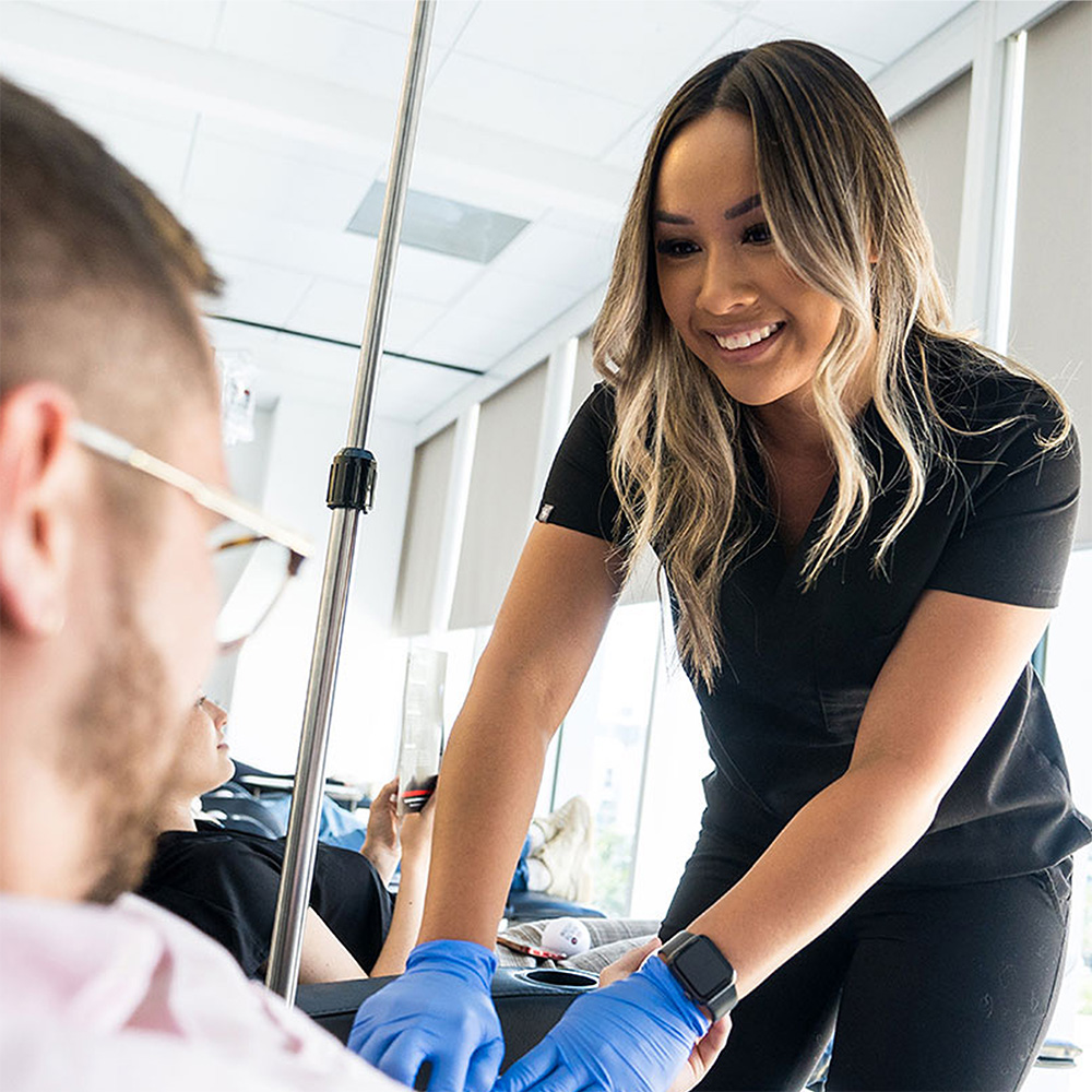 a 10X Health team member prepping a visitor for IV therapy