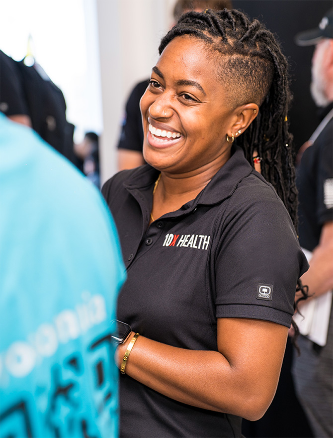 10x health team member smiling at event 01 portrait 670w 01 edited